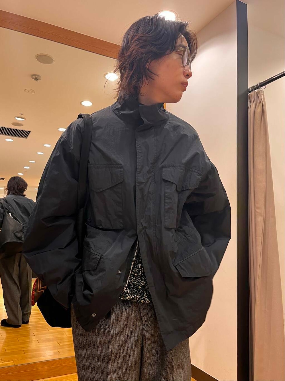 グレー系のナイロンジャケット、ブラック系のニット/セーター、ブラック系のブーツを着用したメンズの秋コーディネートの7枚目の写真