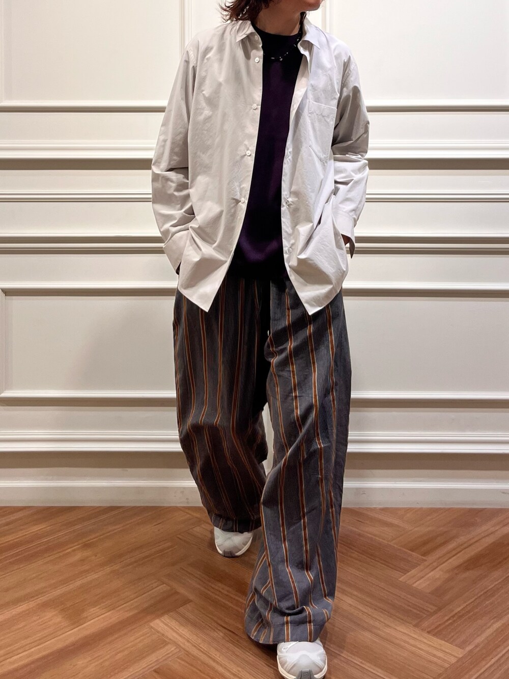 パープル系のニット/セーター、グレー系のシャツ/ブラウス、ホワイト系のスニーカーを着用したメンズの秋コーディネートの4枚目の写真