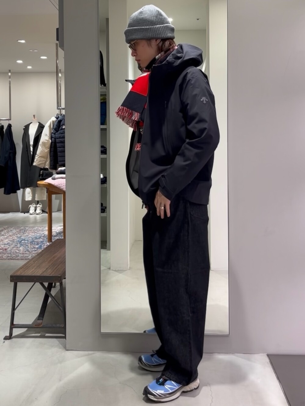 ブルー系のスニーカー、ベージュ系のニット/セーター、ブラック系のデニムパンツを着用したメンズの秋コーディネートの3枚目の写真