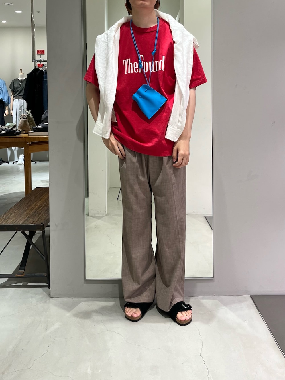 ベージュ系のその他パンツ、レッド系のTシャツ/カットソー、ブラック系のサンダルを着用したメンズの夏コーディネートの4枚目の写真
