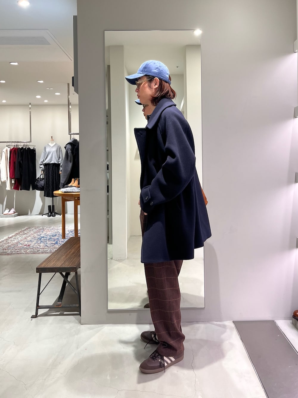 ブラウン系のスニーカー、ブラウン系のトートバッグ、グレー系のニット/セーターを着用したメンズの秋コーディネートの2枚目の写真