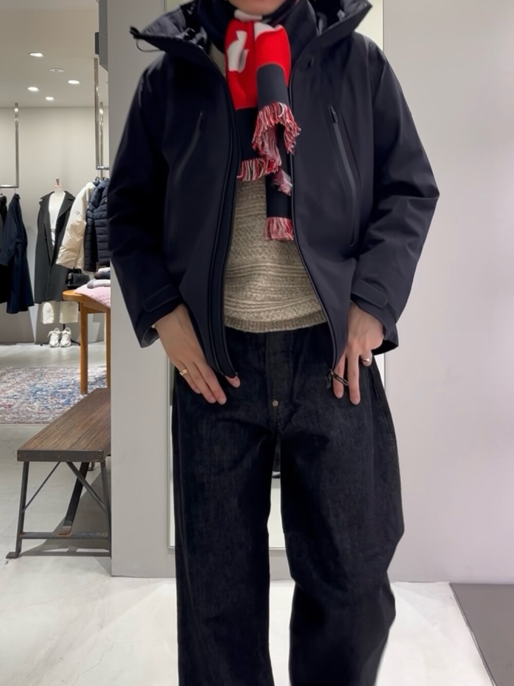 ブルー系のスニーカー、ベージュ系のニット/セーター、ブラック系のデニムパンツを着用したメンズの秋コーディネートの6枚目の写真