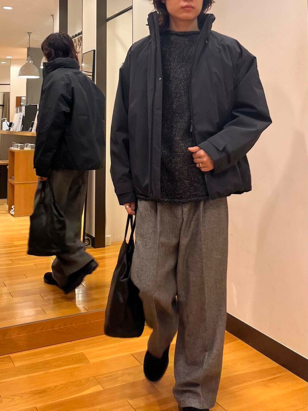 ブラック系のダウンジャケット/コート、ブラック系のニット/セーター、ブラック系のブーツを着用したメンズの秋コーディネートの5枚目の写真