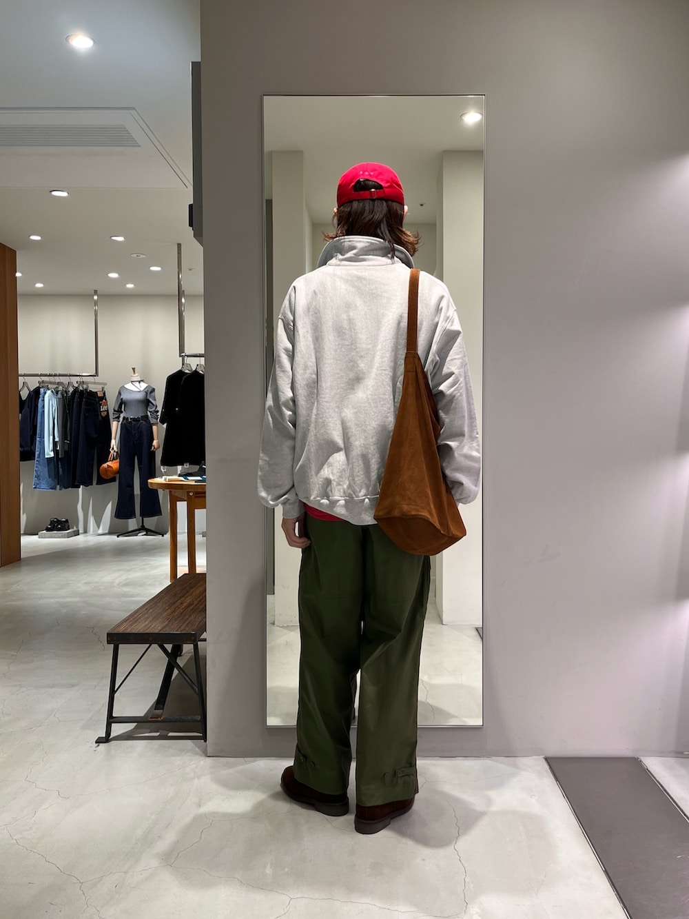 レッド系のTシャツ/カットソー、ブラウン系のトートバッグ、レッド系のキャップを着用したメンズの春コーディネートの3枚目の写真