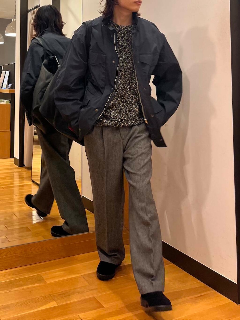 グレー系のナイロンジャケット、ブラック系のニット/セーター、ブラック系のブーツを着用したメンズの秋コーディネートの5枚目の写真