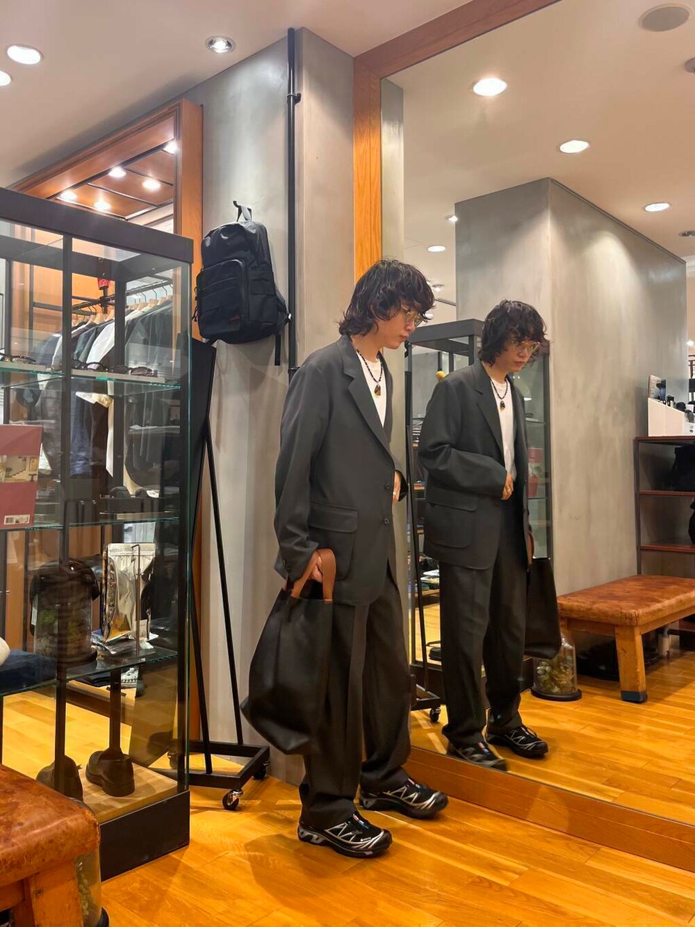 ブラック系のスニーカー、ホワイト系のTシャツ/カットソー、グレー系のテーラードジャケットを着用したメンズの夏コーディネートの2枚目の写真