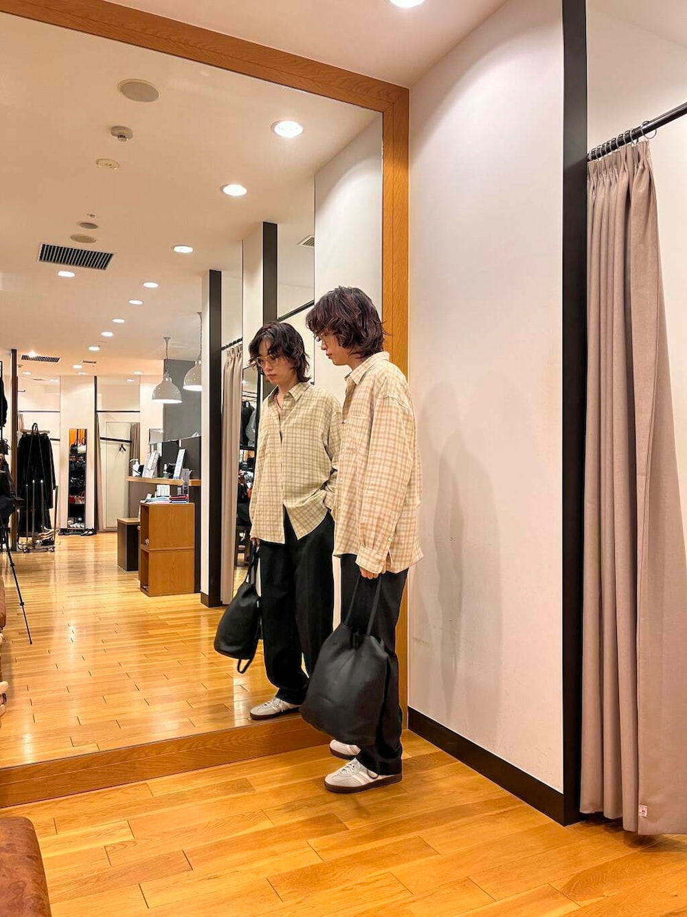 ベージュ系のシャツ/ブラウス、グレー系のスニーカー、ブラック系のトートバッグを着用したメンズの秋コーディネートの2枚目の写真