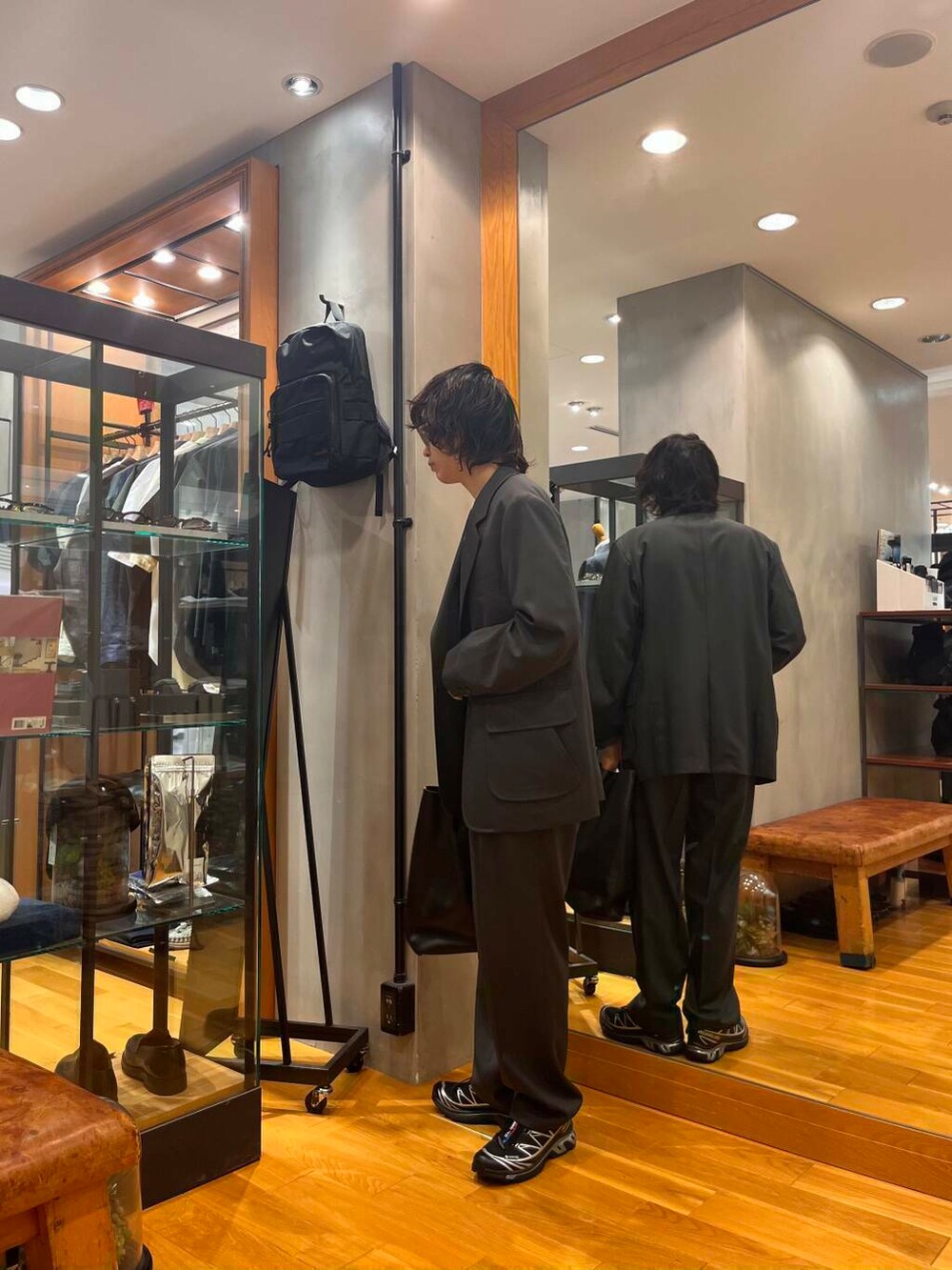 ブラック系のスニーカー、ホワイト系のTシャツ/カットソー、グレー系のテーラードジャケットを着用したメンズの夏コーディネートの3枚目の写真