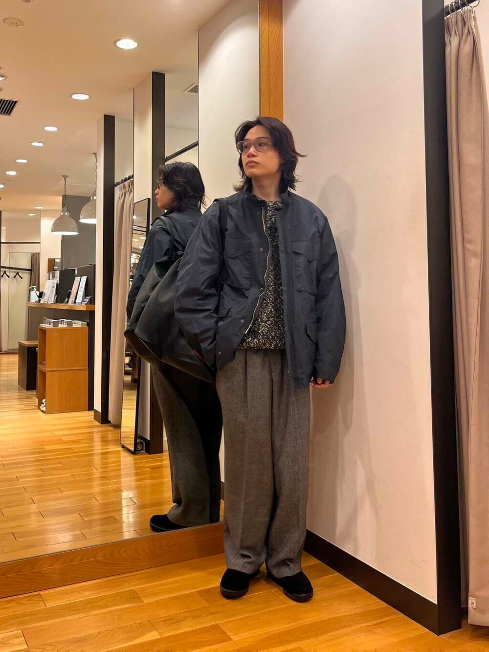 グレー系のナイロンジャケット、ブラック系のニット/セーター、ブラック系のブーツを着用したメンズの秋コーディネートの4枚目の写真