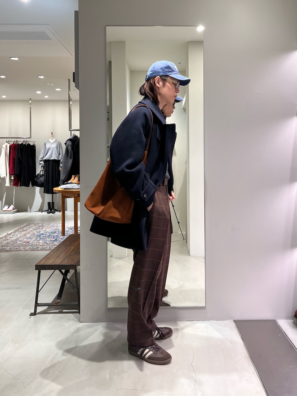 ブラウン系のスニーカー、ブラウン系のトートバッグ、グレー系のニット/セーターを着用したメンズの秋コーディネートの4枚目の写真