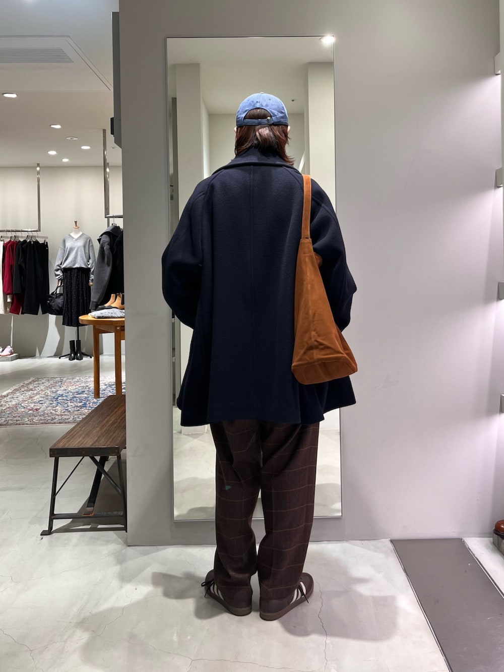 ブラウン系のスニーカー、ブラウン系のトートバッグ、グレー系のニット/セーターを着用したメンズの秋コーディネートの3枚目の写真