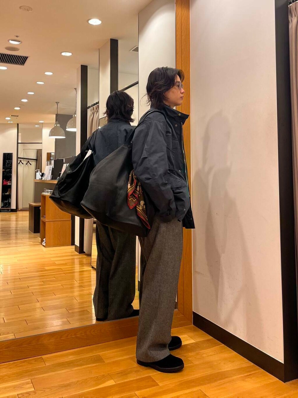 グレー系のナイロンジャケット、ブラック系のニット/セーター、ブラック系のブーツを着用したメンズの秋コーディネートの3枚目の写真