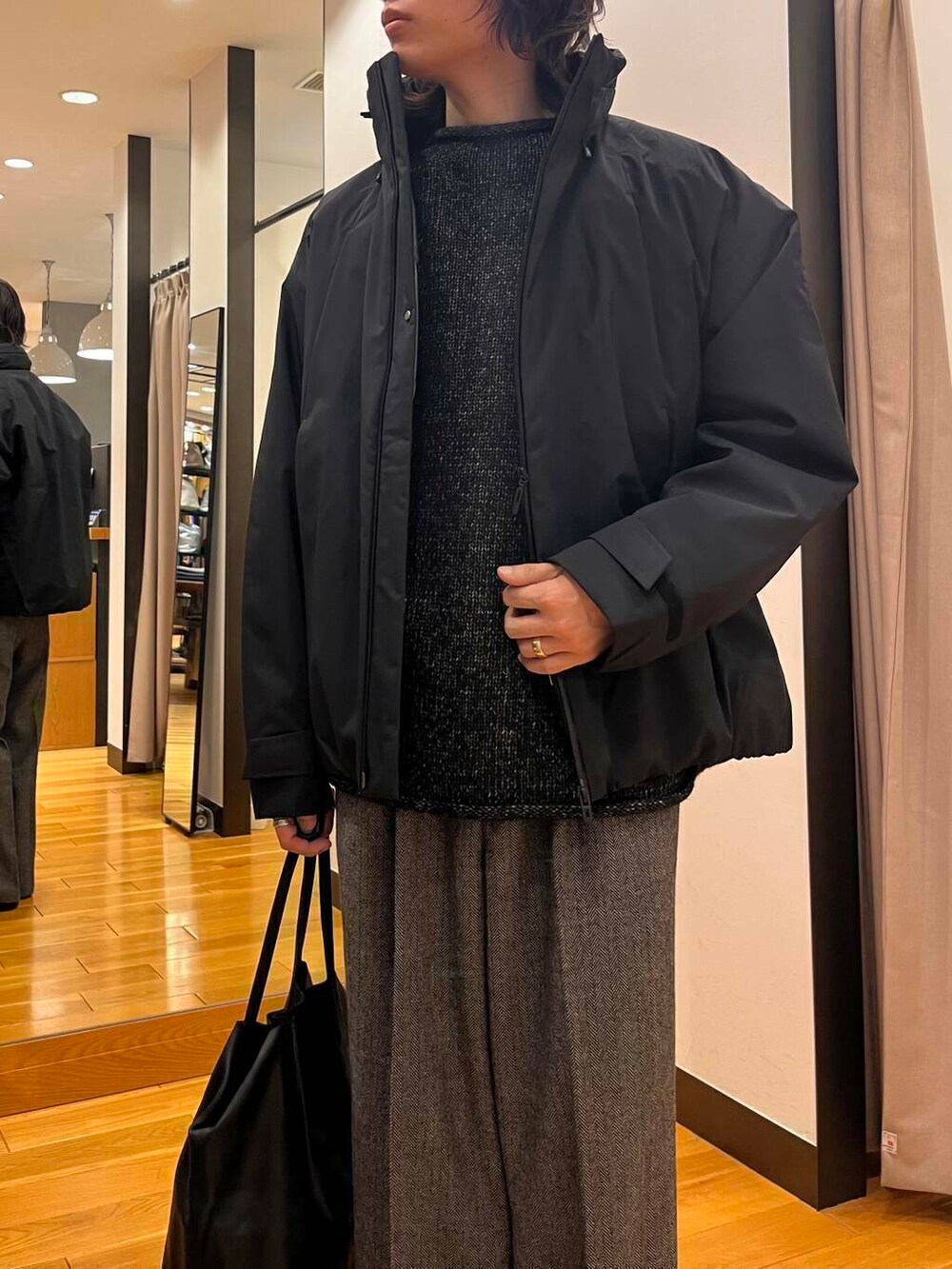 ブラック系のダウンジャケット/コート、ブラック系のニット/セーター、ブラック系のブーツを着用したメンズの秋コーディネートの6枚目の写真