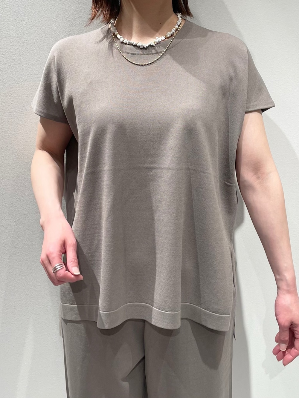 グレー系のニット/セーター、グレー系のその他パンツ、ベージュ系のブルゾンを着用したレディースの春コーディネートの7枚目の写真