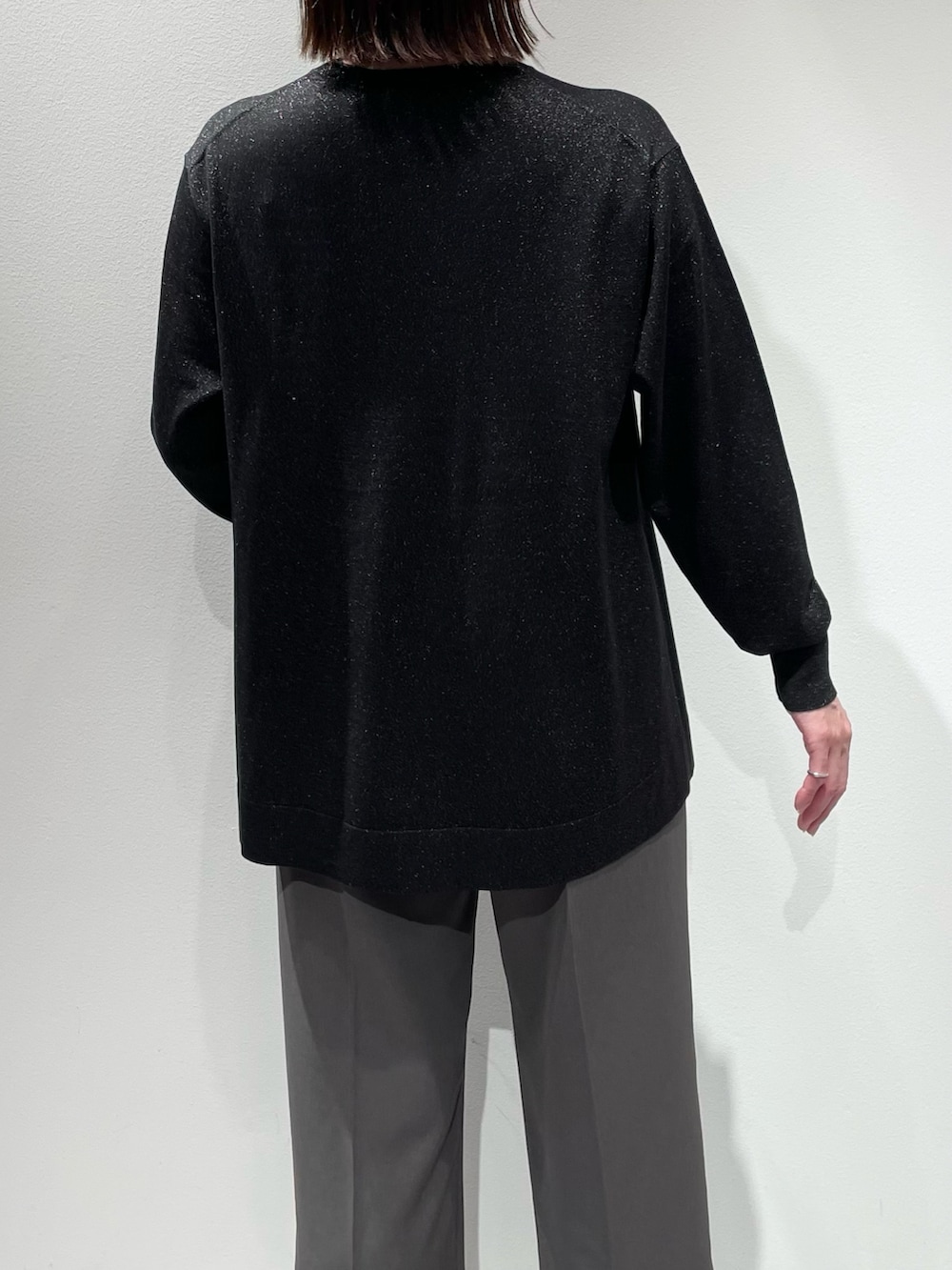 ブラック系のニット/セーター、グレー系のその他パンツ、シルバー系のネックレスを着用したレディースの秋コーディネートの6枚目の写真
