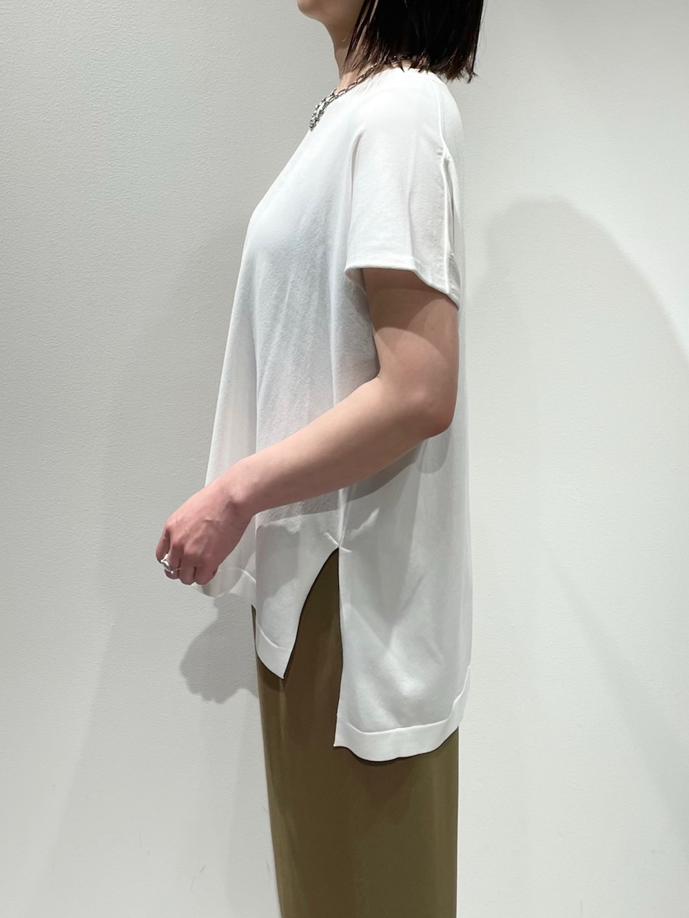 ベージュ系のその他パンツ、ホワイト系のニット/セーター、ブラック系のネックレスを着用したレディースの夏コーディネートの5枚目の写真