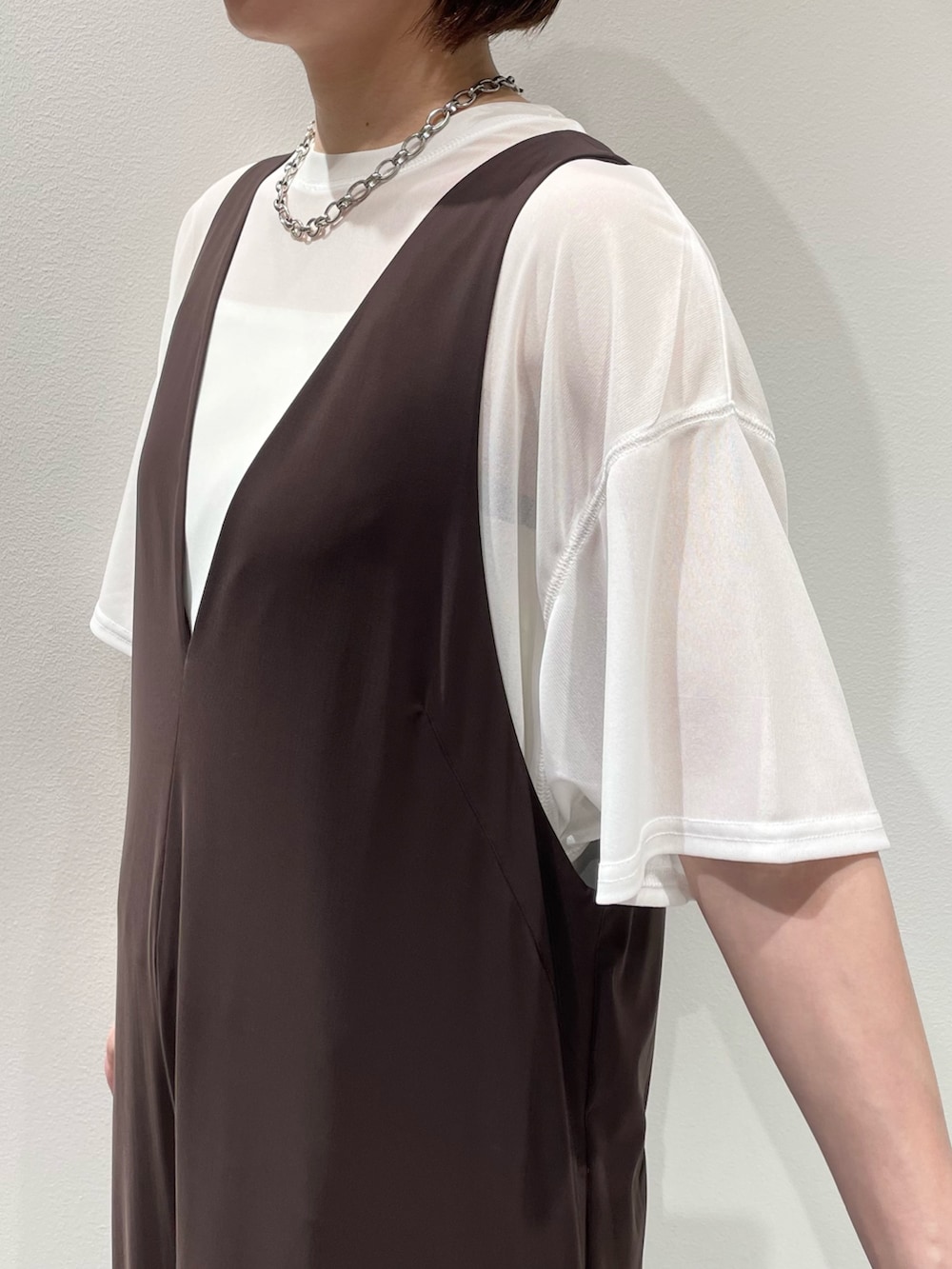 ホワイト系のTシャツ/カットソー、ブラック系のサンダル、ゴールド系のバングル/リストバンドを着用したレディースの夏コーディネートの4枚目の写真