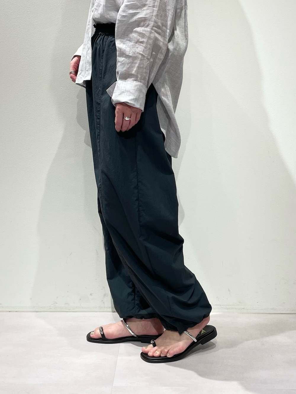 ホワイト系のニット/セーター、パープル系のシャツ/ブラウス、グレー系のその他パンツを着用したレディースの春コーディネートの10枚目の写真