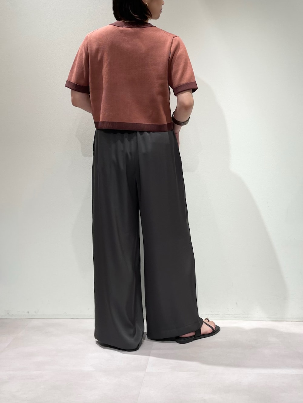 グレー系のその他パンツ、ピンク系のカーディガン/ボレロ、ブラウン系のネックレスを着用したレディースの夏コーディネートの2枚目の写真