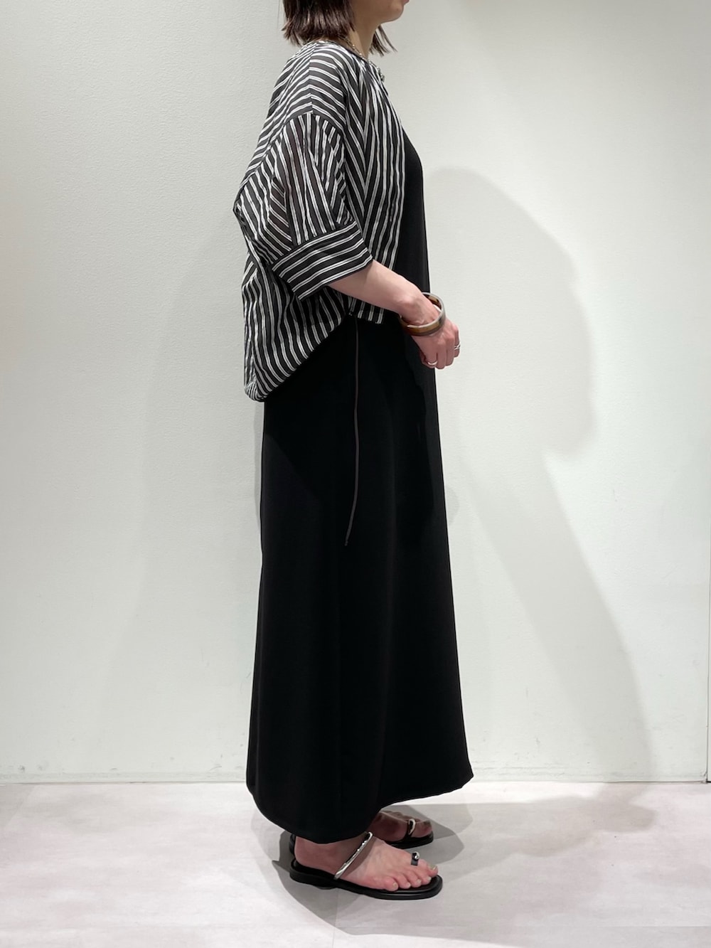 ブラック系のワンピース、ブラック系のシャツ/ブラウス、シルバー系のネックレスを着用したレディースの夏コーディネートの2枚目の写真