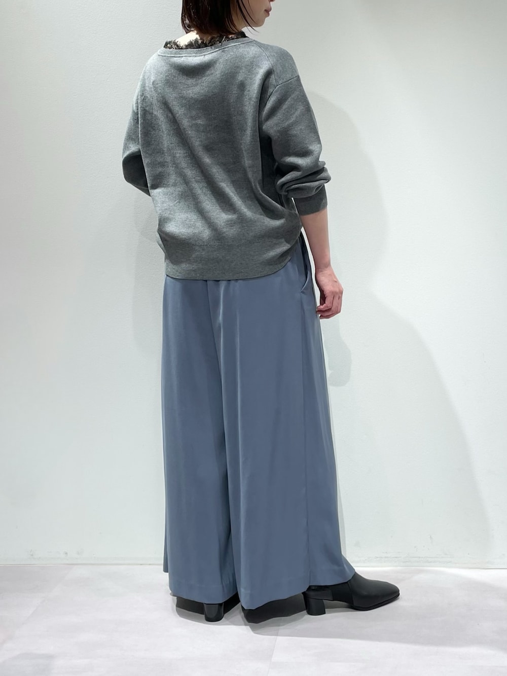 ブルー系のその他パンツ、グレー系のニット/セーター、シルバー系のネックレスを着用したレディースの冬コーディネートの2枚目の写真