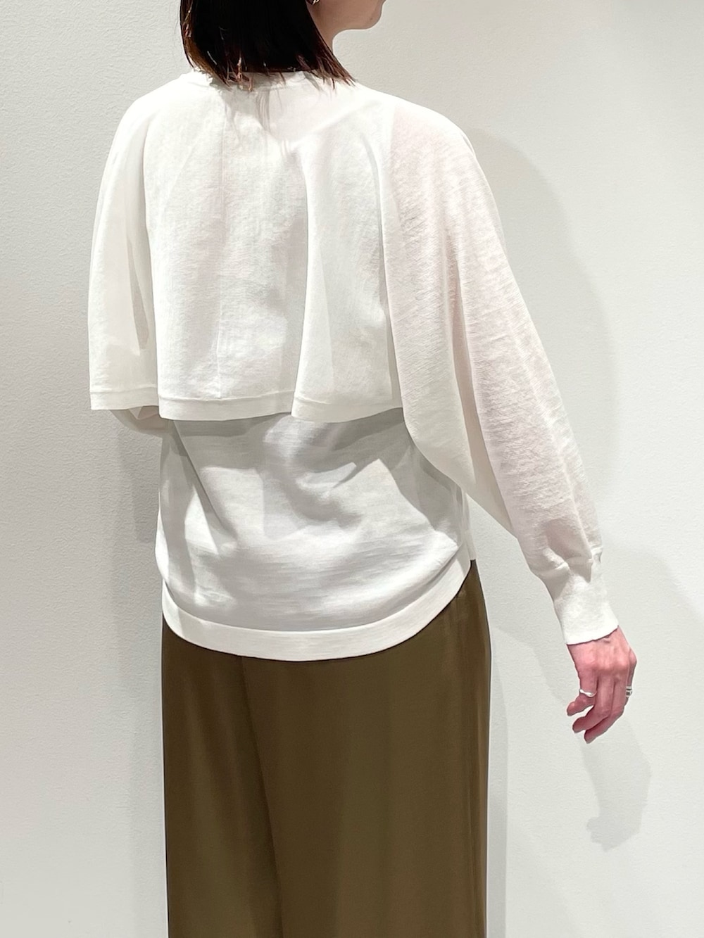 ホワイト系のニット/セーター、グリーン系のその他パンツ、ゴールド系のネックレスを着用したレディースの春コーディネートの6枚目の写真