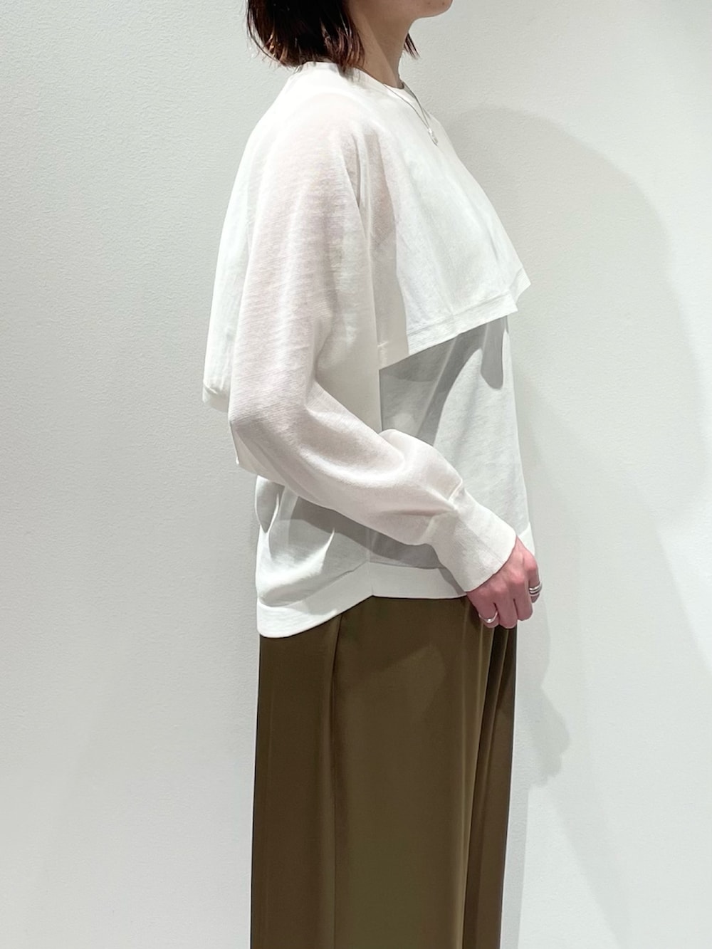 ホワイト系のニット/セーター、グリーン系のその他パンツ、ゴールド系のネックレスを着用したレディースの春コーディネートの5枚目の写真