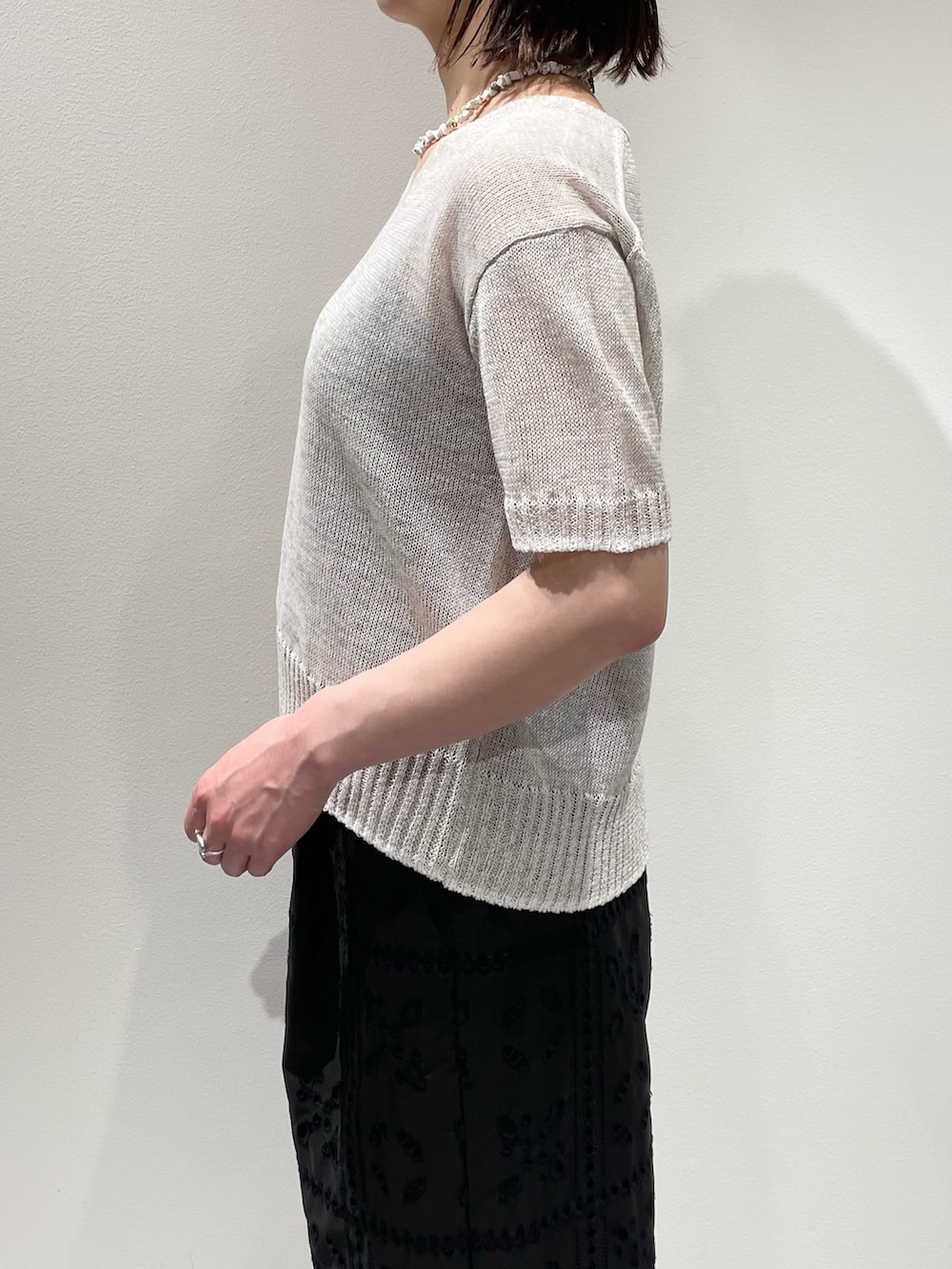 ブラック系のその他パンツ、ホワイト系のニット/セーター、ホワイト系のネックレスを着用したレディースの春コーディネートの5枚目の写真