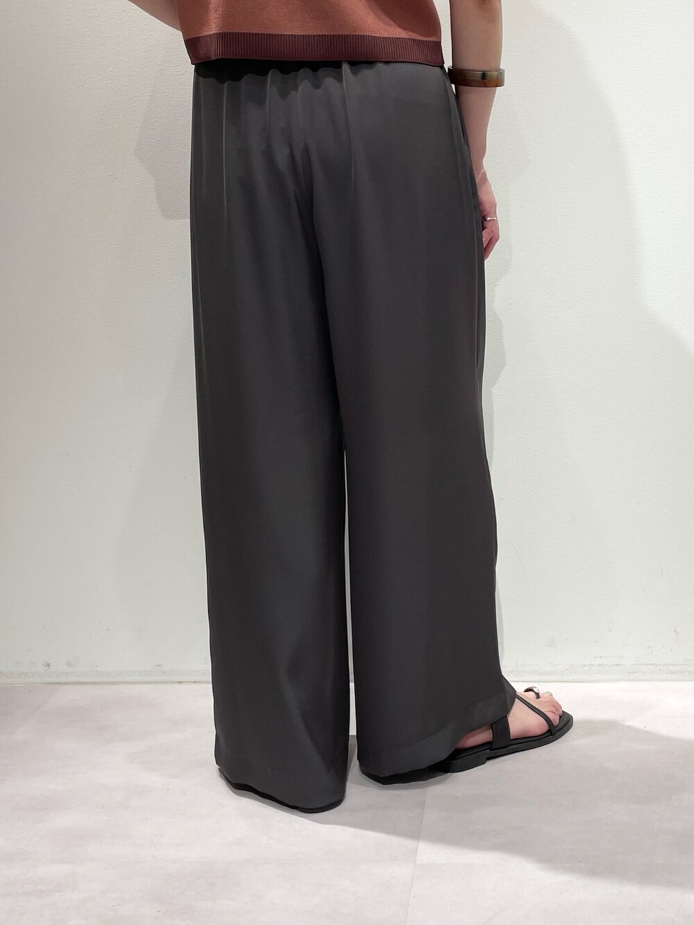 グレー系のその他パンツ、ピンク系のカーディガン/ボレロ、ブラウン系のネックレスを着用したレディースの夏コーディネートの9枚目の写真