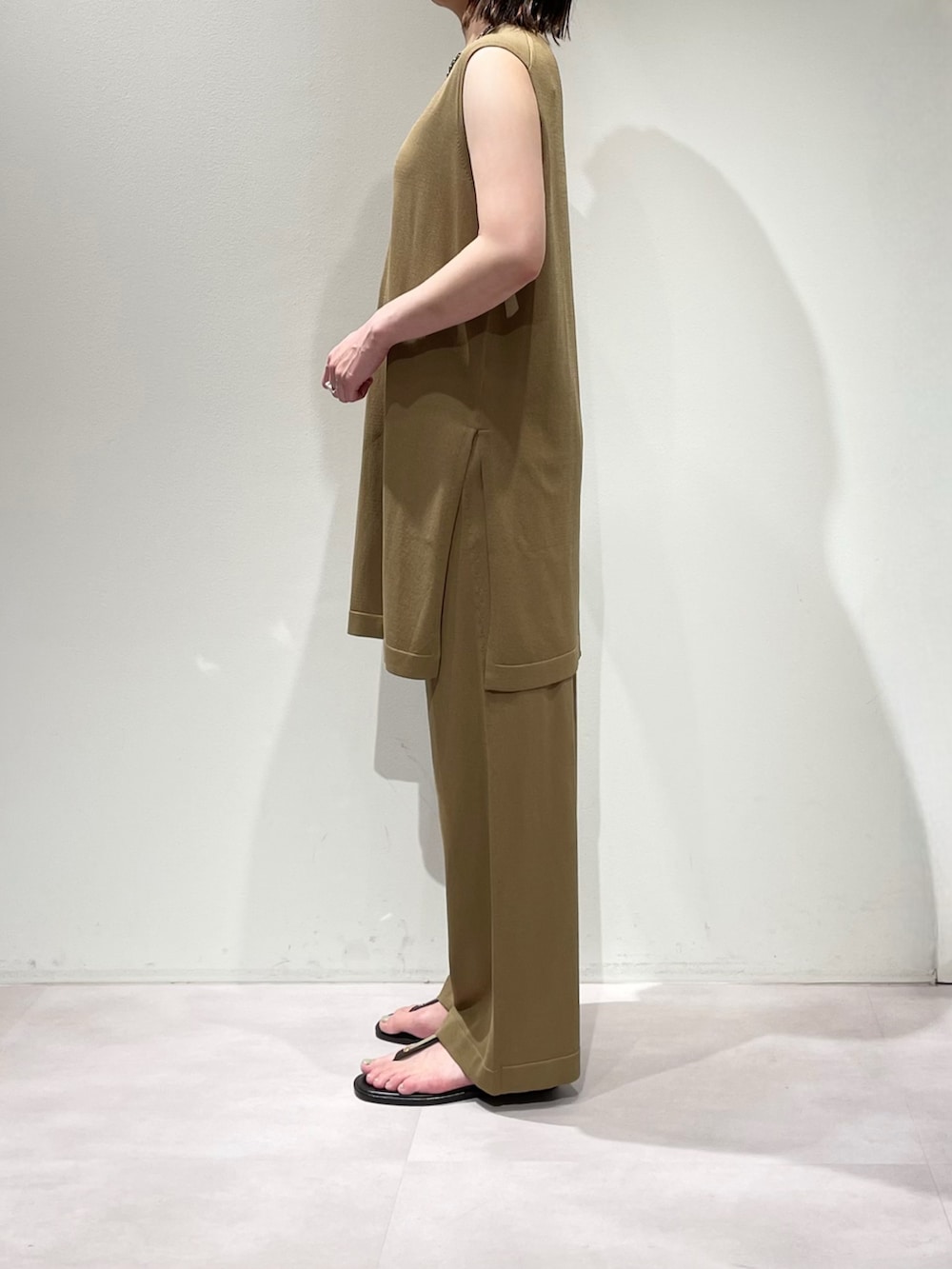 ベージュ系のその他パンツ、ベージュ系のニット/セーター、シルバー系のネックレスを着用したレディースの夏コーディネートの2枚目の写真