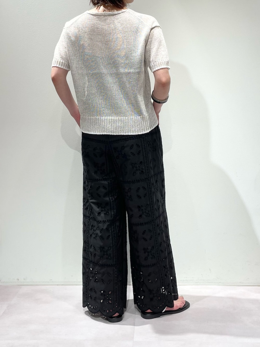 ブラック系のその他パンツ、ホワイト系のニット/セーター、ホワイト系のネックレスを着用したレディースの春コーディネートの3枚目の写真