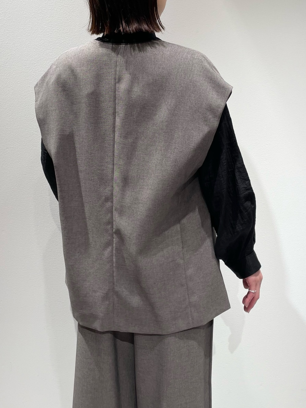グレー系のその他パンツ、グレー系のベスト、ブラック系のシャツ/ブラウスを着用したレディースの秋コーディネートの6枚目の写真