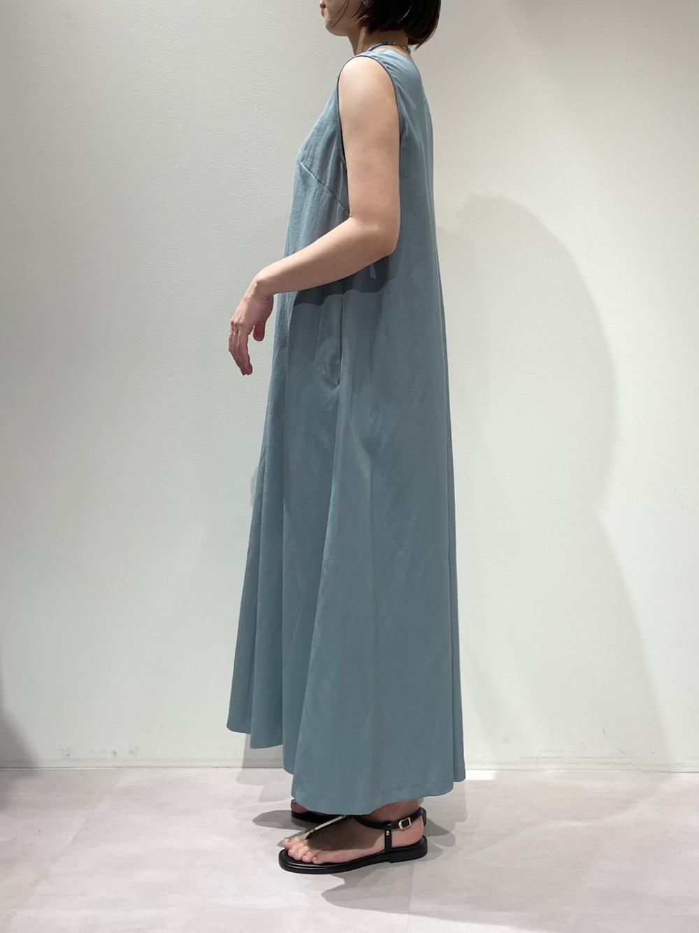 ブラウン系のサンダル、ブルー系のワンピース、ブラック系のショルダーバッグを着用したレディースの夏コーディネートの5枚目の写真