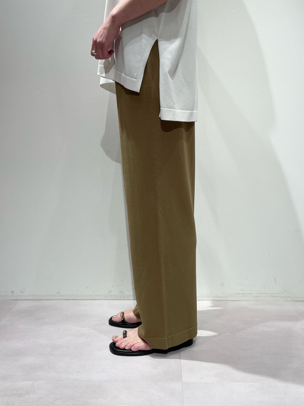 ベージュ系のその他パンツ、ホワイト系のニット/セーター、ブラック系のネックレスを着用したレディースの夏コーディネートの8枚目の写真
