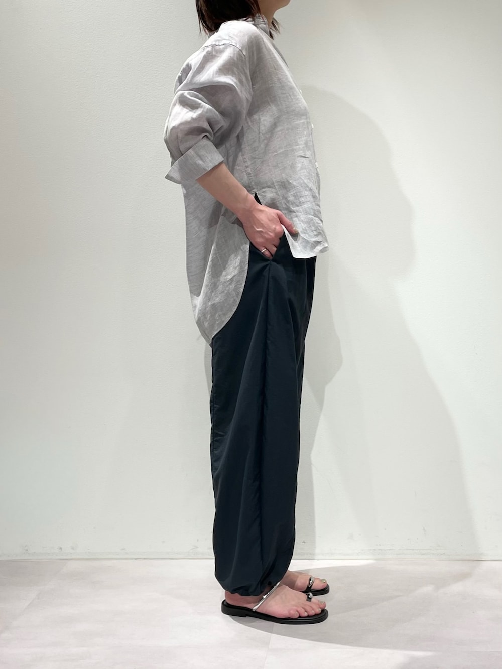 ホワイト系のニット/セーター、パープル系のシャツ/ブラウス、グレー系のその他パンツを着用したレディースの春コーディネートの2枚目の写真