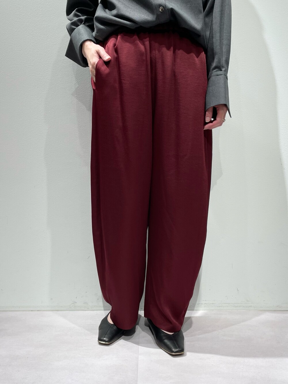 グレー系のシャツ/ブラウス、ブラック系のタンクトップ、レッド系のその他パンツを着用したレディースの秋コーディネートの8枚目の写真