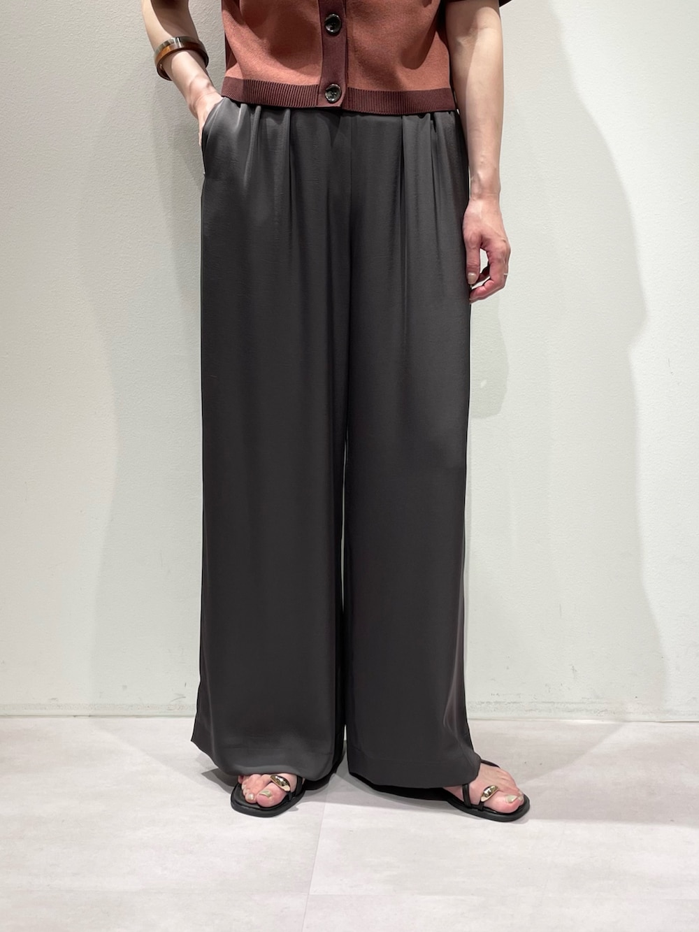 グレー系のその他パンツ、ピンク系のカーディガン/ボレロ、ブラウン系のネックレスを着用したレディースの夏コーディネートの7枚目の写真