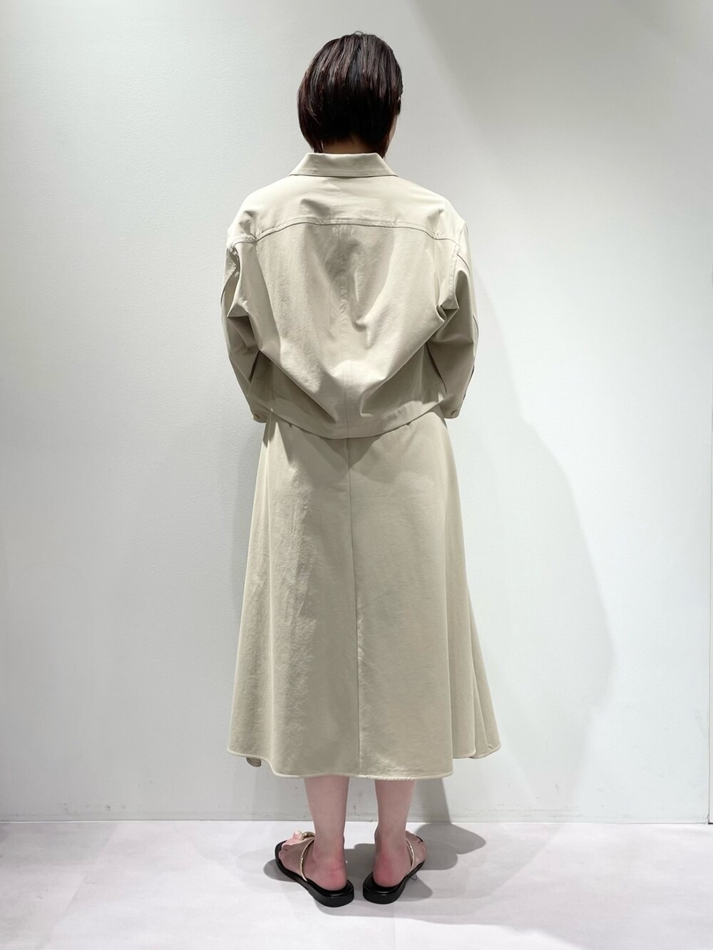 ベージュ系のトートバッグ、ベージュ系のワンピース、ベージュ系のブルゾンを着用したレディースの春コーディネートの4枚目の写真