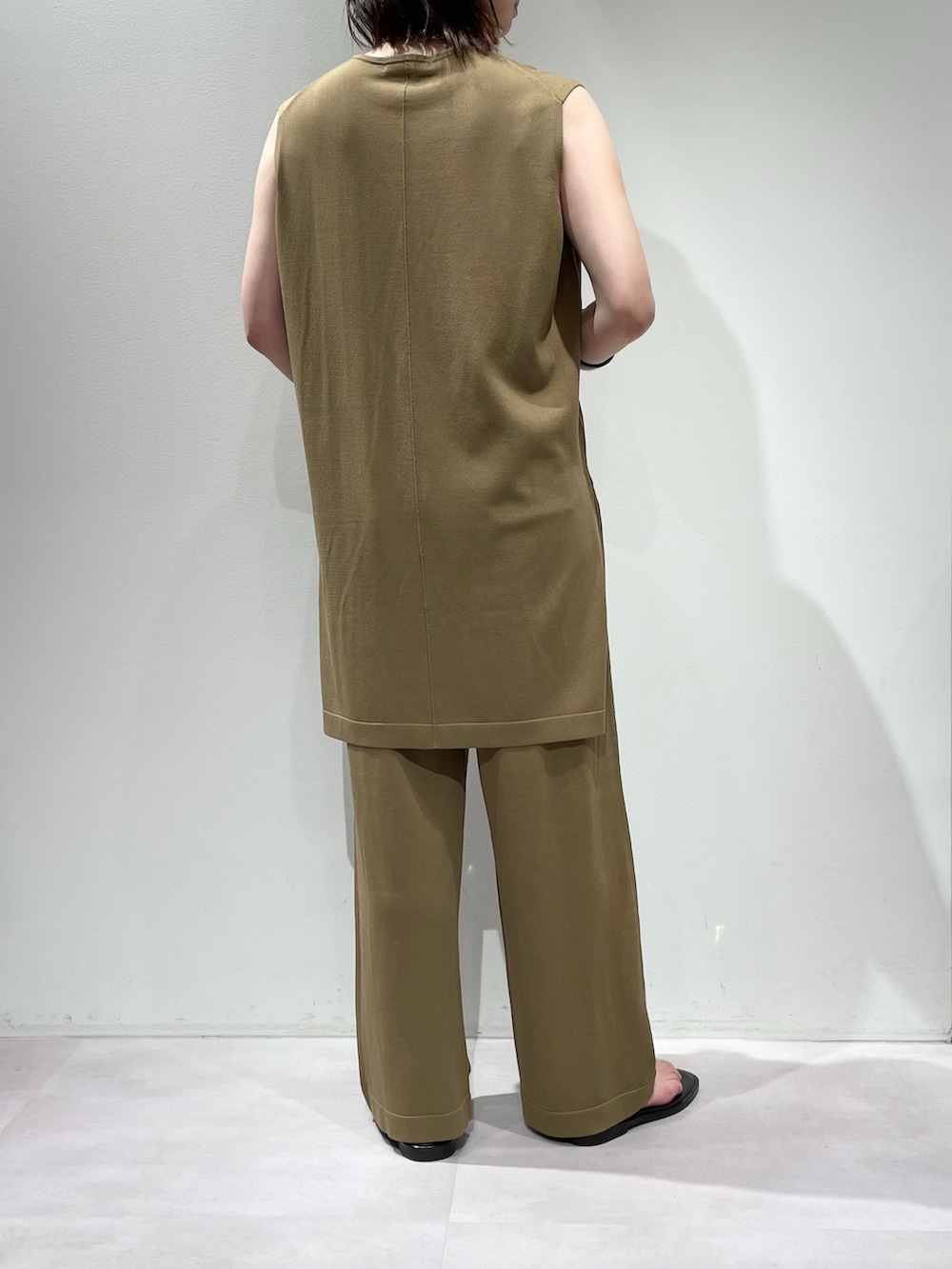 ベージュ系のその他パンツ、ベージュ系のニット/セーター、シルバー系のネックレスを着用したレディースの夏コーディネートの3枚目の写真