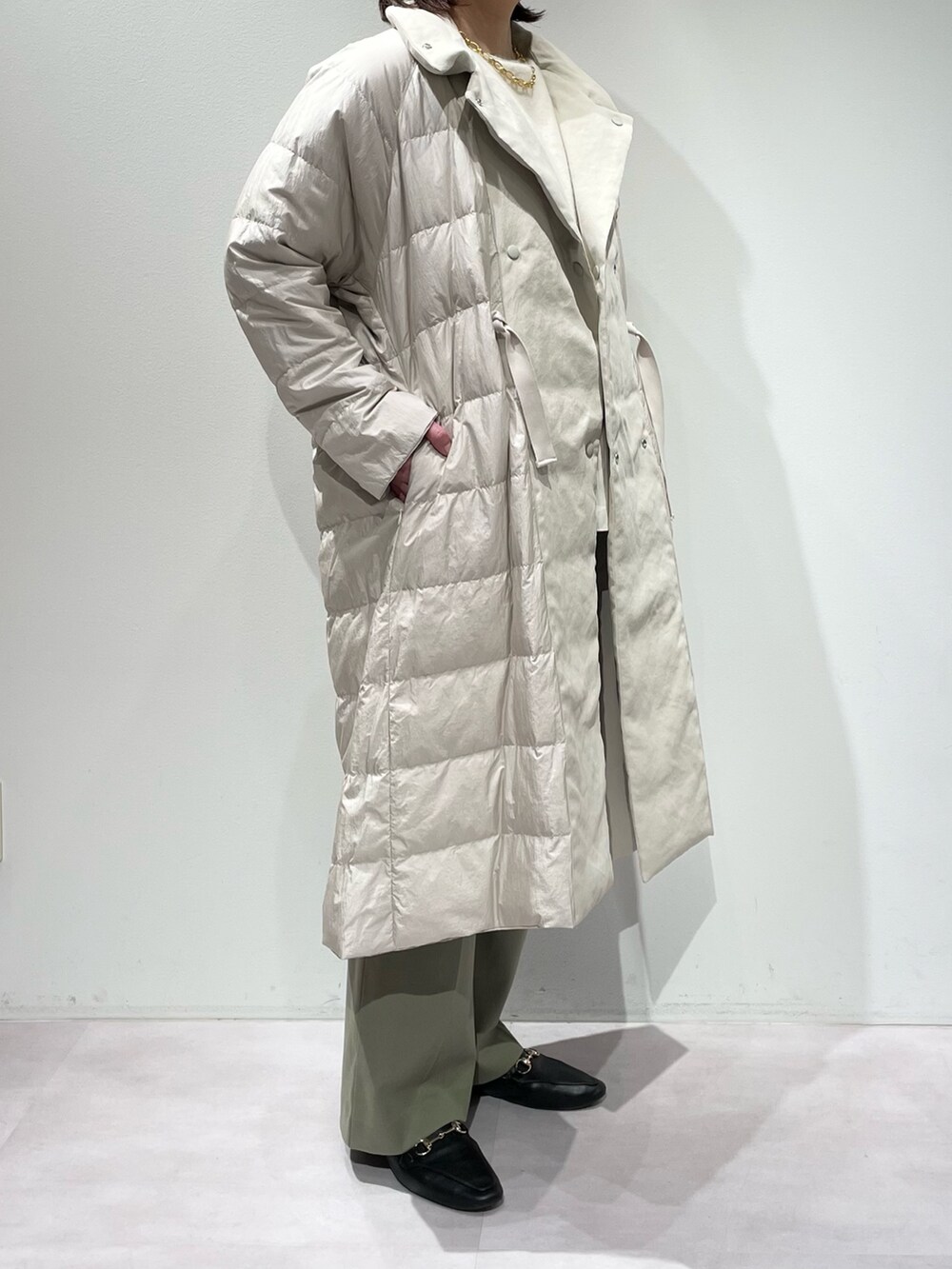 グリーン系のその他パンツ、ベージュ系のダウンジャケット/コート、ホワイト系のニット/セーターを着用したレディースの秋コーディネートの10枚目の写真