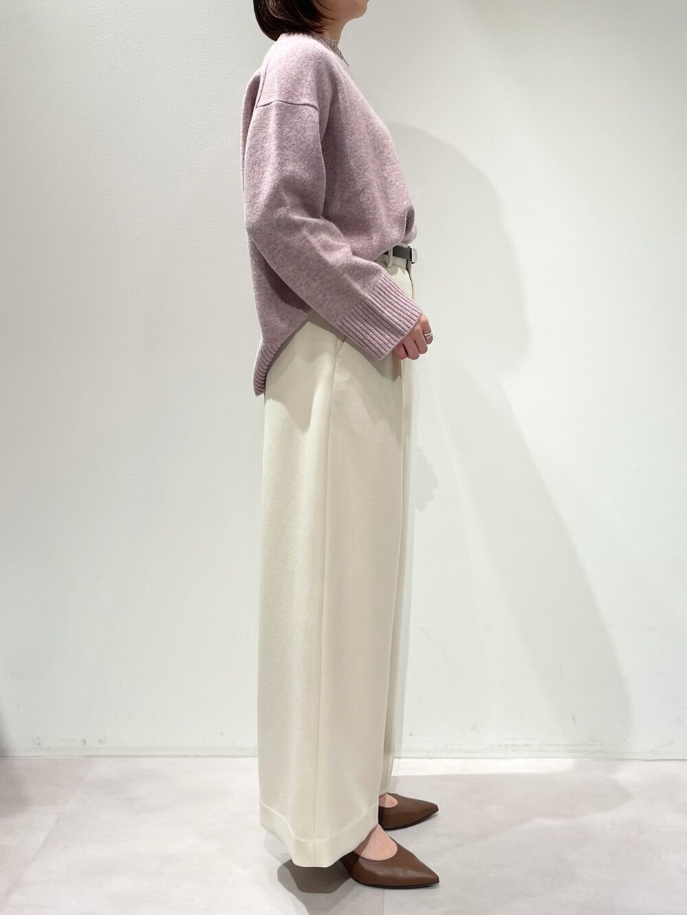 ピンク系のニット/セーター、ホワイト系のその他パンツ、シルバー系のネックレスを着用したレディースの冬コーディネートの2枚目の写真