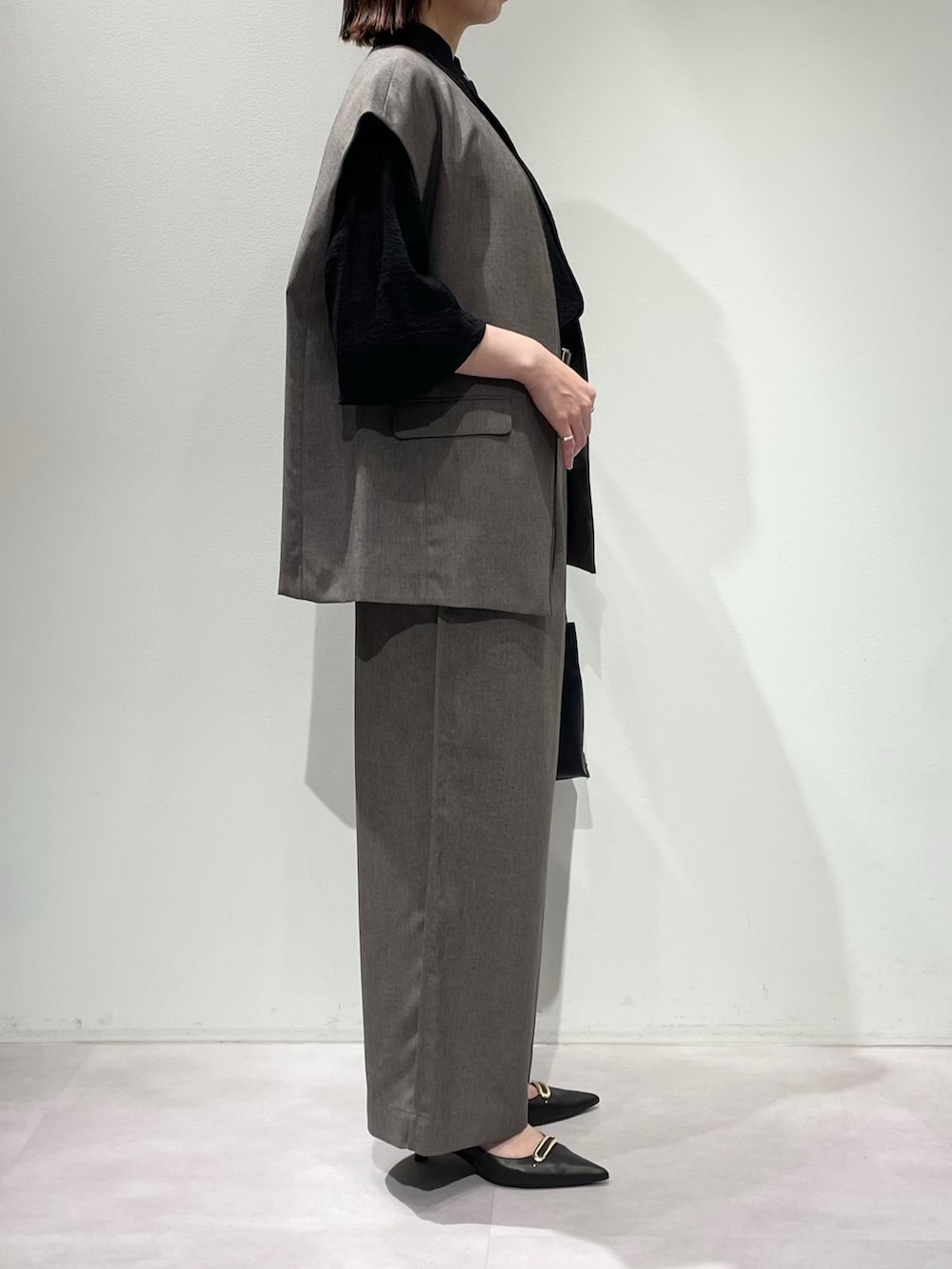 グレー系のその他パンツ、グレー系のベスト、ブラック系のシャツ/ブラウスを着用したレディースの秋コーディネートの2枚目の写真