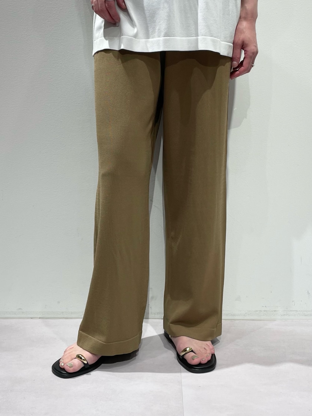 ベージュ系のその他パンツ、ホワイト系のニット/セーター、ブラック系のネックレスを着用したレディースの夏コーディネートの7枚目の写真