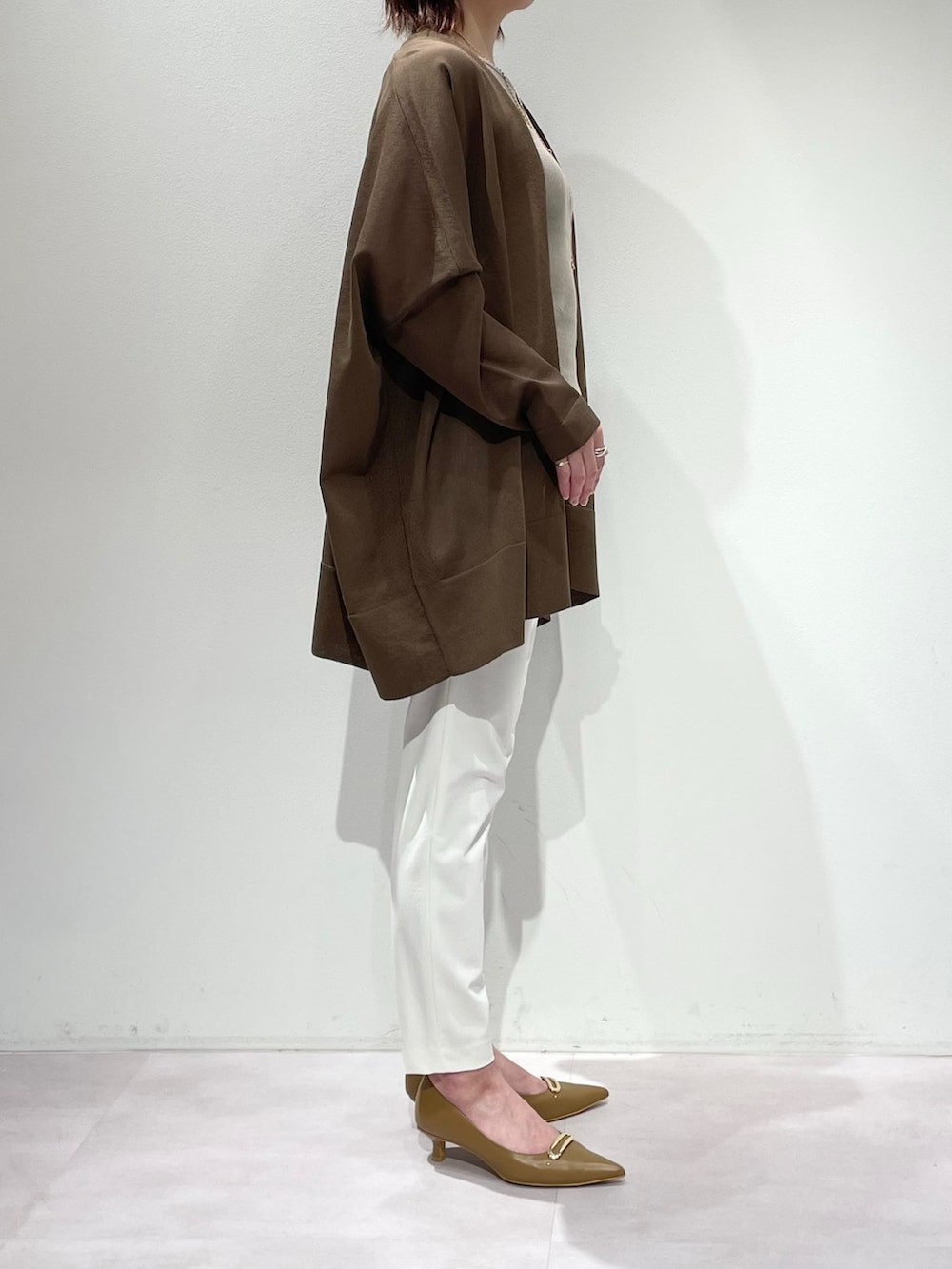 グリーン系のシャツ/ブラウス、ベージュ系のタンクトップ、ホワイト系のその他パンツを着用したレディースの春コーディネートの2枚目の写真