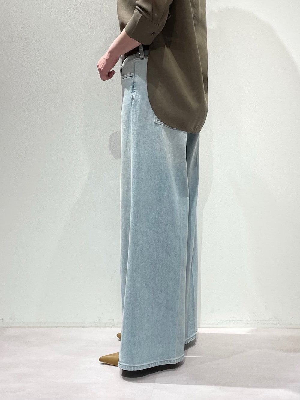 グリーン系のシャツ/ブラウス、ブルー系のデニムパンツ、ブラウン系のベルトを着用したレディースの冬コーディネートの8枚目の写真