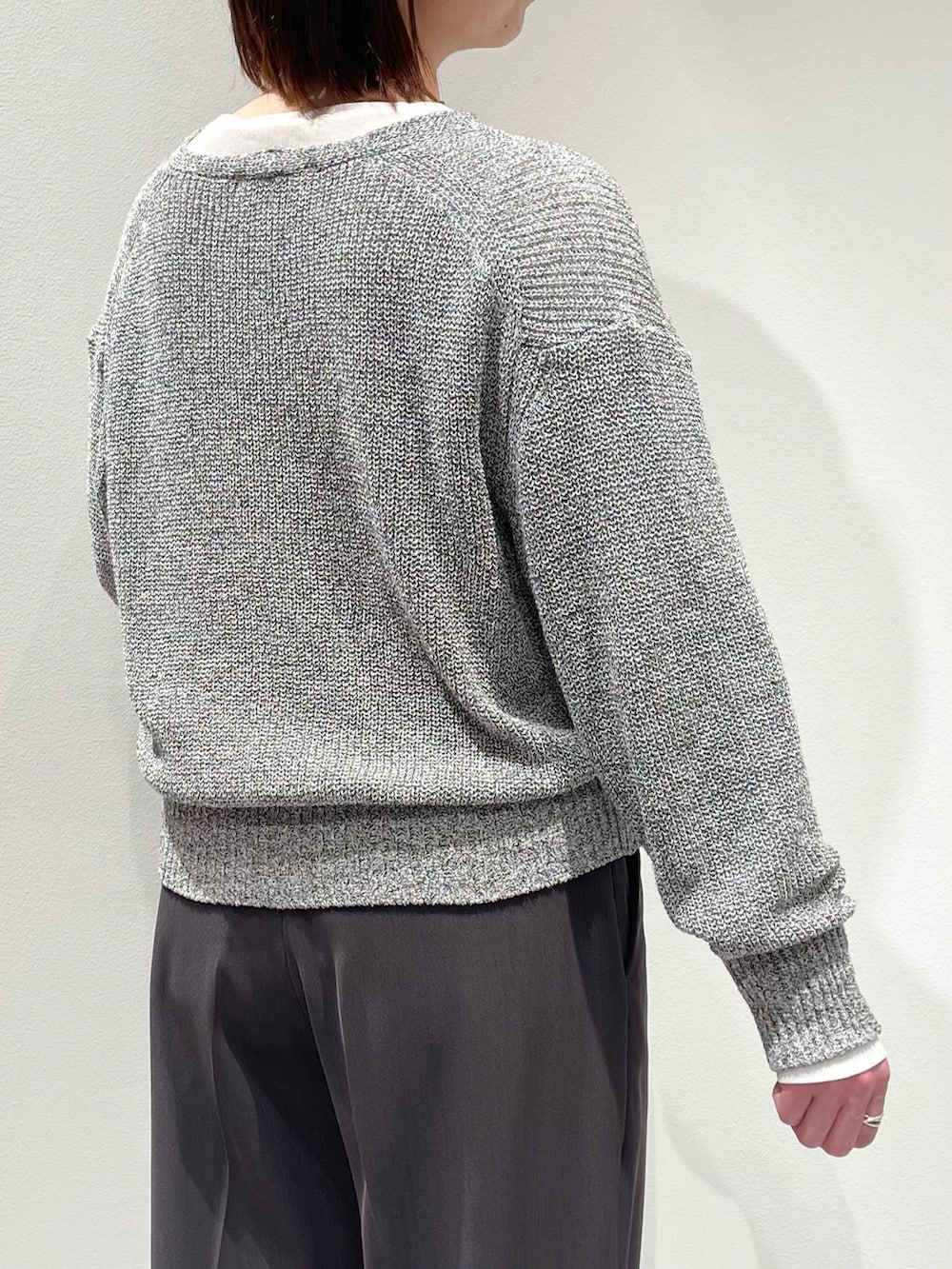 グレー系のその他パンツ、グレー系のニット/セーター、ホワイト系のTシャツ/カットソーを着用したレディースの春コーディネートの6枚目の写真