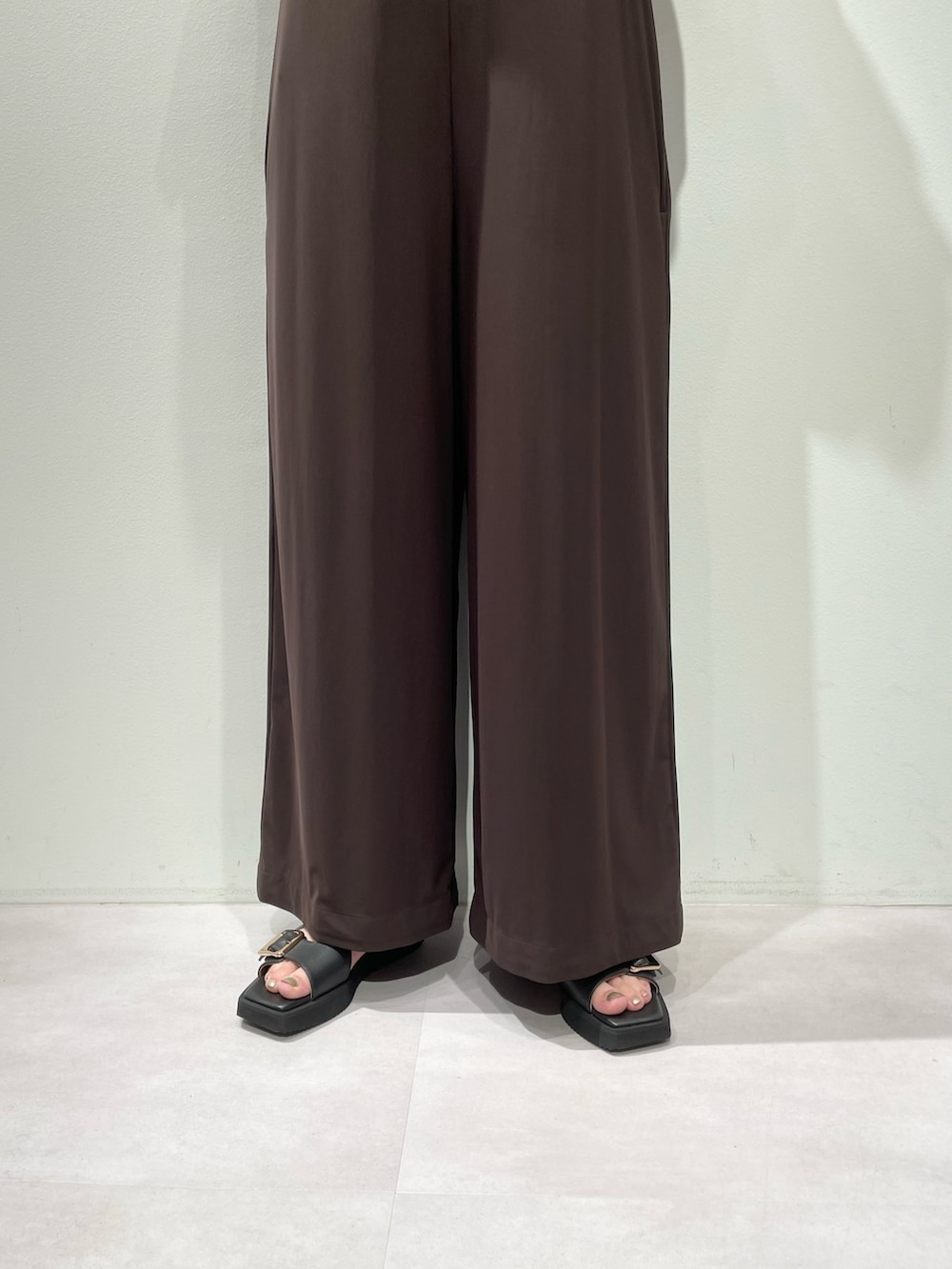 ホワイト系のTシャツ/カットソー、ブラック系のサンダル、ゴールド系のバングル/リストバンドを着用したレディースの夏コーディネートの6枚目の写真