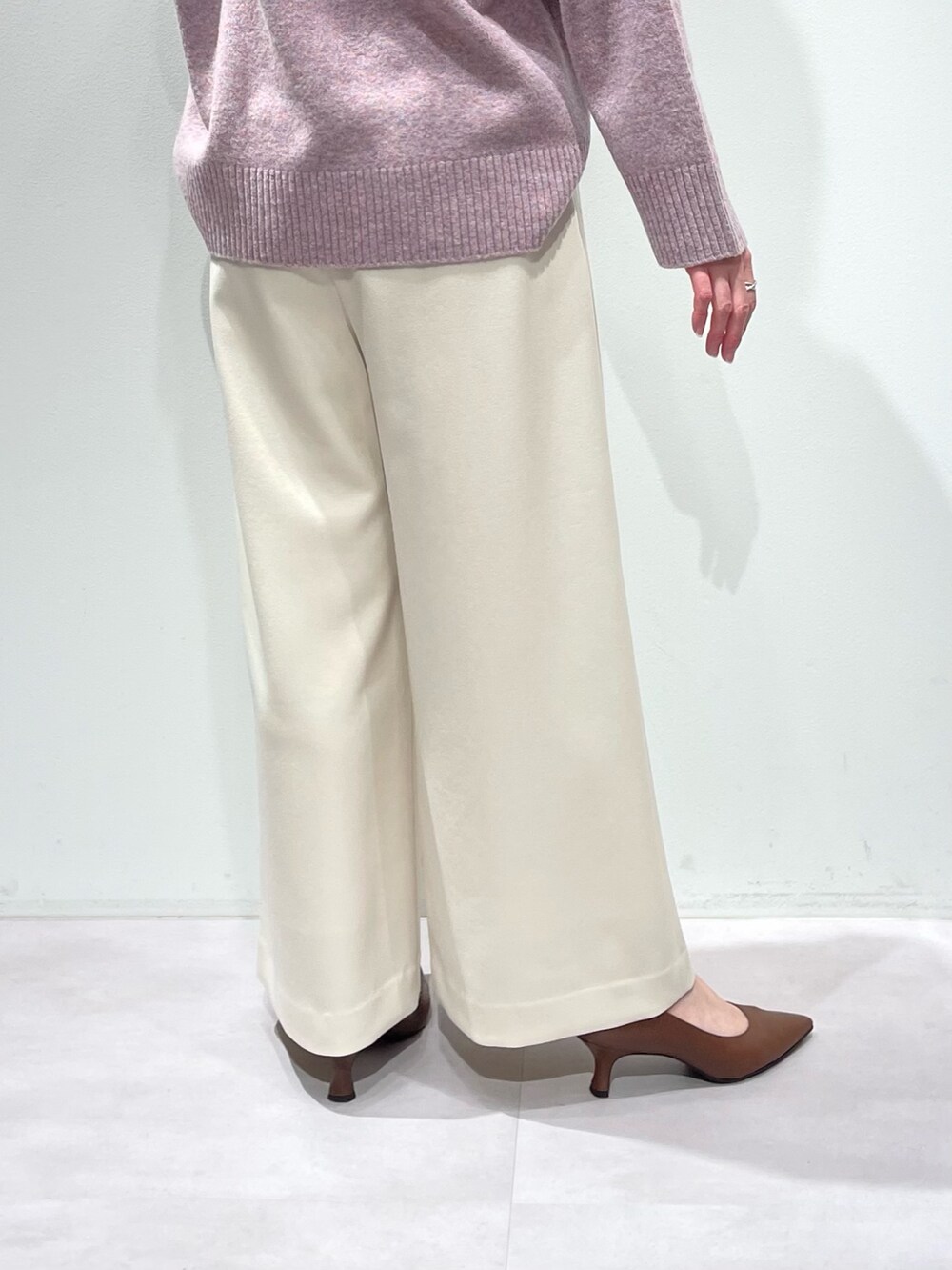 ピンク系のニット/セーター、ホワイト系のその他パンツ、シルバー系のネックレスを着用したレディースの冬コーディネートの9枚目の写真