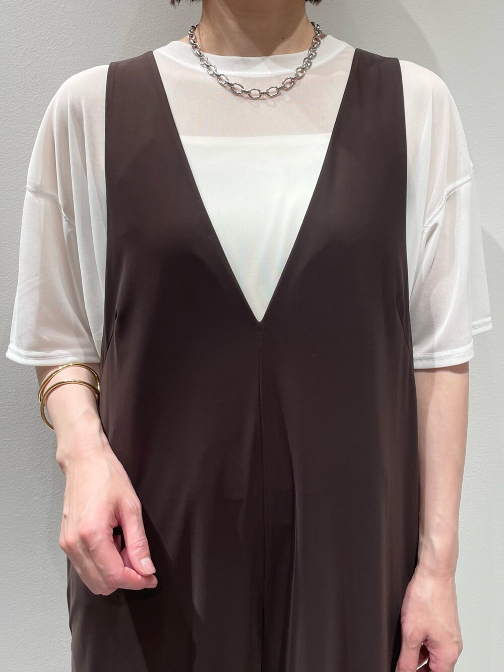 ホワイト系のTシャツ/カットソー、ブラック系のサンダル、ゴールド系のバングル/リストバンドを着用したレディースの夏コーディネートの3枚目の写真