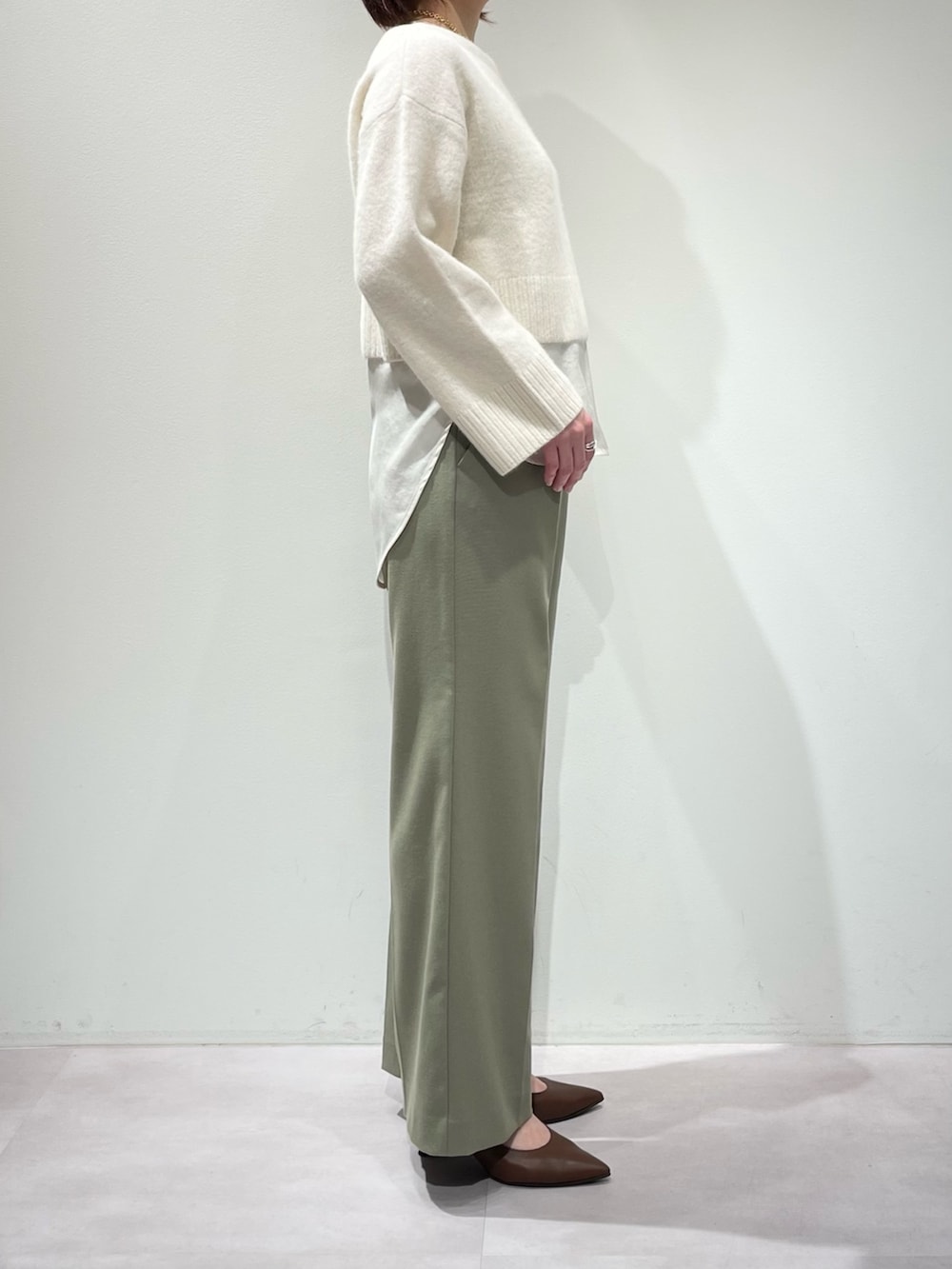 グリーン系のその他パンツ、ホワイト系のニット/セーター、ホワイト系のタンクトップを着用したレディースの冬コーディネートの8枚目の写真